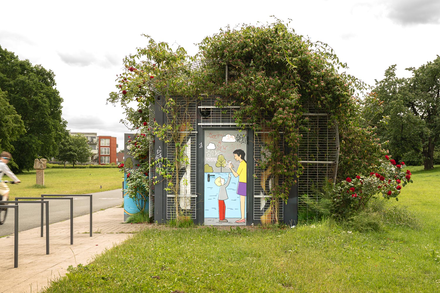 Öffentlicher WC-Container für die Bremer Stadtreinigung an der Weser Seitenansicht bewachsen