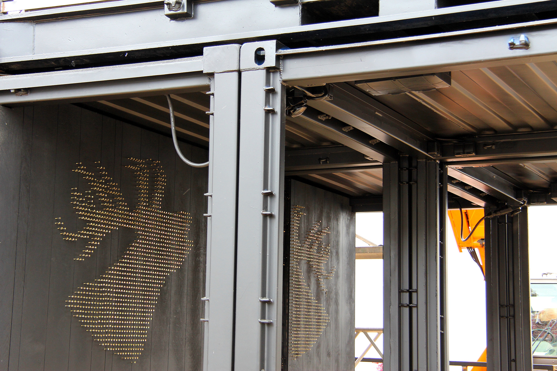 Stahlträger und Verbindungen der Containerkonstruktion und Hirschmotive an den Wänden