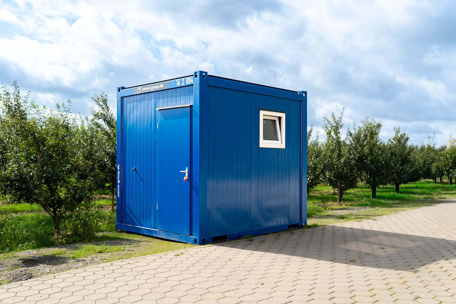 Mietcontainer SA1 auf einem Obsthof im Alten Land während der Apfelernte direkt neben den Bäumen